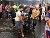Iraqi firefighters and civilians carry bodies of victims killed in a car bomb at a commercial area in Karrada neighbourhood, Baghdad, Iraq, Sunday, July 3, 2016